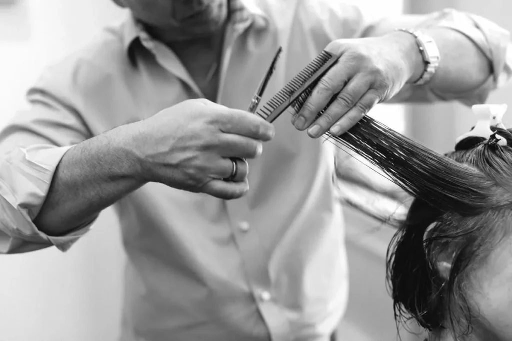 Michael Roffi performing a precision haircut with scissors and comb